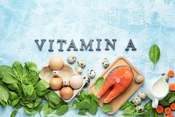 Healthy products rich in vitamin A on color background