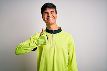 Young handsome sportsman doing sport wearing sportswear over isolated white background doing happy thumbs up gesture with hand. Approving expression looking at the camera showing success.