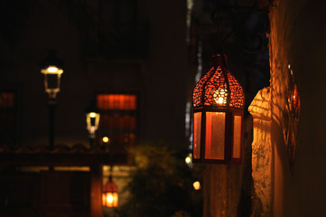 Spanish street lantern hanging on an old wall lighting dimly © Concepcion RamalloM-