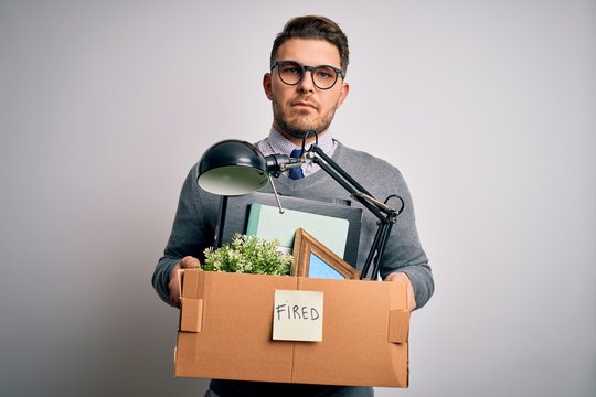 Young Business Man With Blue Eyes Holding Box From The Office Beeing Fired From Job With A Confident Expression On Smart Face Thinking Serious