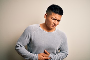 Young handsome latin man wearing casual sweater standing over isolated white background with hand...
