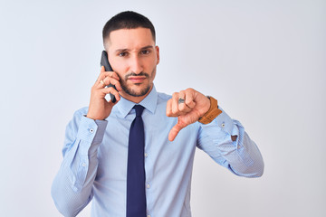 Young handsome business man calling using smartphone over isolated background with angry face, negative sign showing dislike with thumbs down, rejection concept