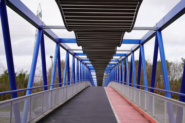 Overground Pedestrian blue Metal Crossing bridge walkway red black path Modern building perspective