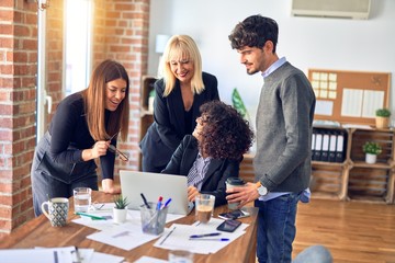 Group of business workers smiling happy and confident. Working together with smile on face  using laptop at the office