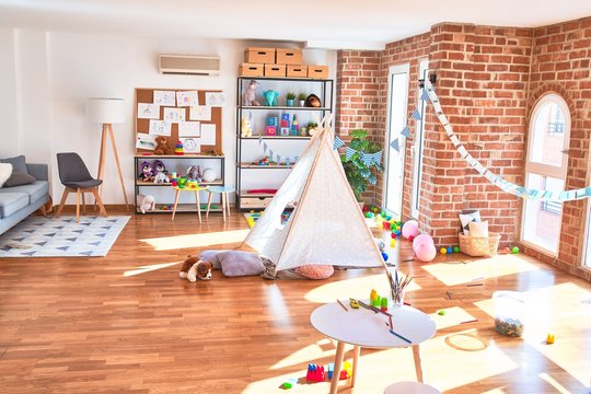 Picture of preschool playroom with colorful furniture and toys around empty kindergarten