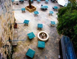 Aerial view on empty garden cafe tables in the town square of the medieval Lebanese city of Deir El...