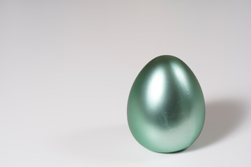 green easter eggs on the white table.