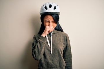 Young beautiful chinese woman wearing bike helmet over isolated white background feeling unwell and coughing as symptom for cold or bronchitis. Health care concept.