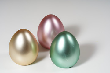 Colorful easter eggs on white wall and wood table.
