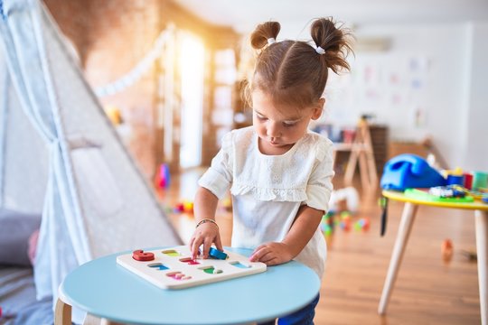 Young beautiful toddler learning mathematics playing with maths game at kindergaten
