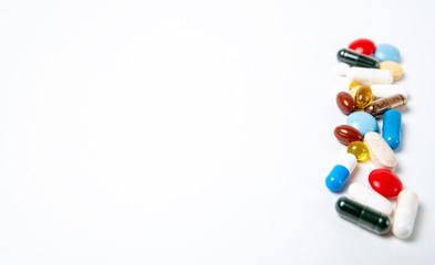 many colored pills on the right side on a white background