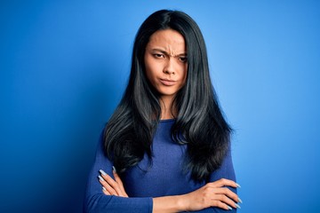 Obraz premium Young beautiful chinese woman wearing casual t-shirt over isolated blue background skeptic and nervous, disapproving expression on face with crossed arms. Negative person.