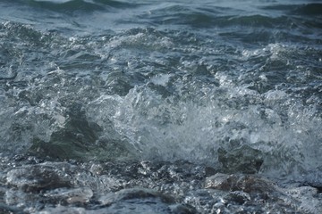 Dark sea wave and foam running ashore