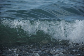 Dark sea wave and foam running ashore