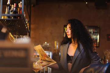 Plakat Elegant lady in a business suit, in a restaurant at a bar counter alone
