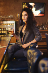 Fototapeta na wymiar Elegant lady in a business suit, in a restaurant at a bar counter alone