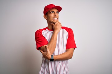 Young handsome african american sportsman wearing striped baseball t-shirt and cap Thinking worried about a question, concerned and nervous with hand on chin