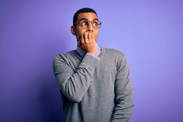 Handsome african american businessman wearing glasses and tie over purple background looking stressed and nervous with hands on mouth biting nails. Anxiety problem.