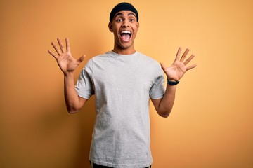 Handsome african american sportsman doing sport wearing sportswear over yellow background celebrating crazy and amazed for success with arms raised and open eyes screaming excited. Winner concept