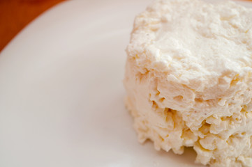 Cottage cheese on a white plate. Healthy food.