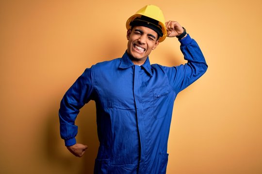 Young Handsome African American Worker Man Wearing Blue Uniform And Security Helmet Stretching Back, Tired And Relaxed, Sleepy And Yawning For Early Morning