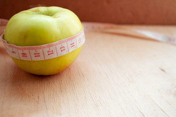 Apple wrapped in tape measure. Healthy lifestyle. Lose Weight By Summer. Proper nutrition. Diet. 