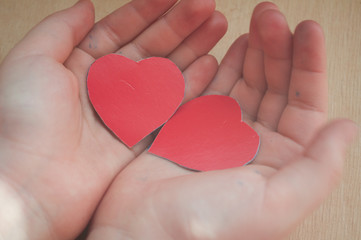 Obraz premium two red hearts in children's hands, healthcare, love, organ donation, family insurance and the concept of CSR, World Heart Day, World Health Day, fair trade