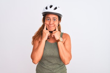 Middle age mature cyclist woman wearing safety helmet over isolated background Smiling with open mouth, fingers pointing and forcing cheerful smile