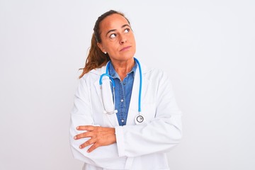 Fototapeta premium Middle age mature doctor woman wearing stethoscope over isolated background smiling looking to the side and staring away thinking.