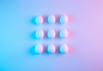 Creative simple geometrical pattern made of white chicken eggs. Creative minimal holographic Easter concept.