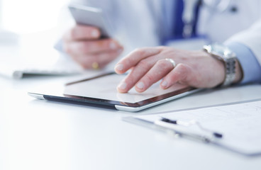 Portrait of senior doctor in office sitting at the desk