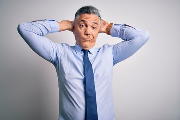 Middle age handsome grey-haired business man wearing elegant shirt and tie Doing bunny ears gesture with hands palms looking cynical and skeptical. Easter rabbit concept.