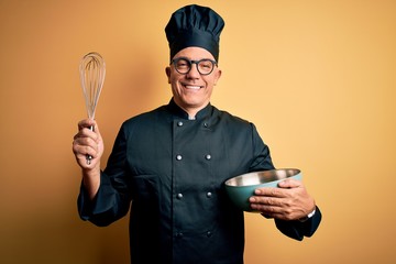 Middle age handsome grey-haired chef man wearing cooker uniform and hat using whisk with a happy...
