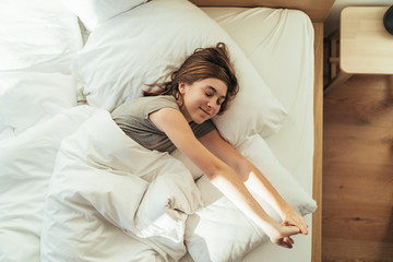 Obraz na płótnie Canvas Teenage girl waking up in the bedroom