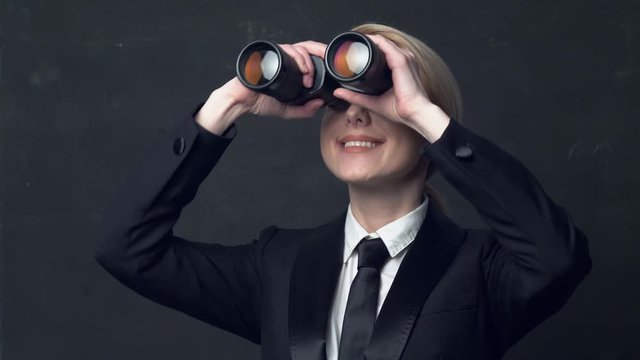 businesswoman in a classic business suit and binoculars