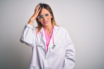 Middle age beautiful doctor woman wearing pink stethoscope over isolated white background confuse and wonder about question. Uncertain with doubt, thinking with hand on head. Pensive concept.