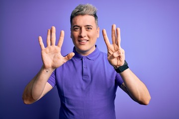 Young handsome modern man wearing casual purple t-shirt over isolated background showing and pointing up with fingers number eight while smiling confident and happy.