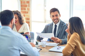 Group of business workers working together. Sitting on desk using laptop reading documents at the office