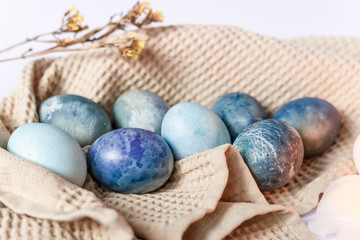 Easter atmosphere. Dyed Easter eggs and spring flowers on a white background. Easter atmosphere.