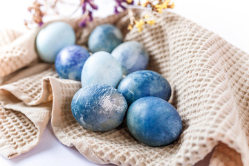 Easter atmosphere. Dyed Easter eggs and spring flowers on a white background. Easter atmosphere.