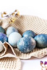 Easter atmosphere. Dyed Easter eggs and spring flowers on a white background. Easter atmosphere.