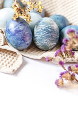 Easter atmosphere. Dyed Easter eggs and spring flowers on a white background. Easter atmosphere.