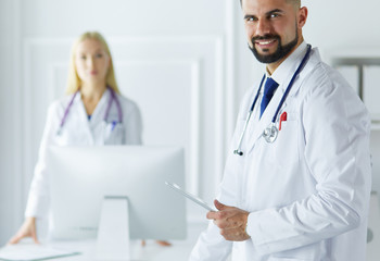 Happy medical team of doctors, man and woman, isolated over white background in a hospital room