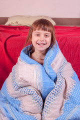 Funny portrait of cute active little girl having fun in bed and doesn't want going to fall asleep. Vertica image.