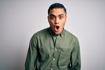 Young brazilian man wearing casual shirt standing over isolated white background afraid and shocked with surprise expression, fear and excited face.
