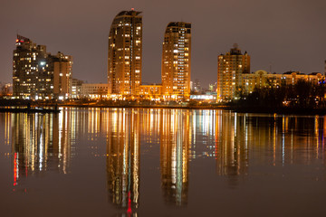 Fototapeta na wymiar Kiev, obolon. The houses of the night city are reflected in the water.