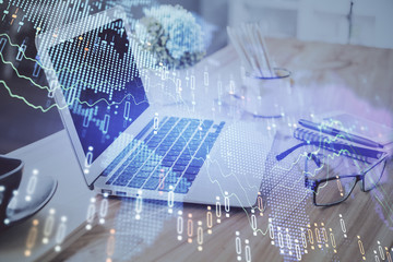 Stock market chart hologram drawn on personal computer background. Double exposure. Concept of investment.