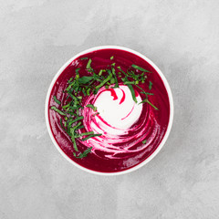 Beet cream soup with parsley on a light background