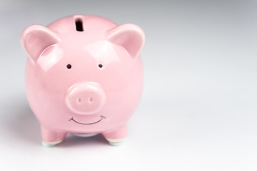 Pink piggy bank on white background with reflection