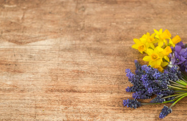 One of the first spring flowers on the wooden background, arranged in the bouquet